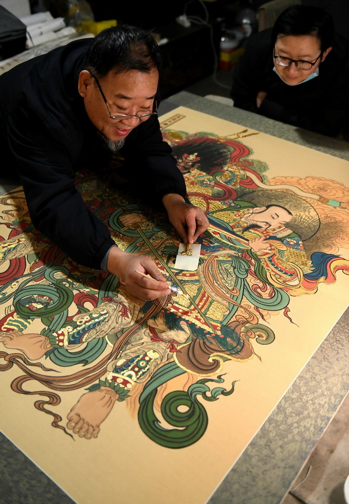 12月23日，民間畫師姚淑龍?jiān)谑仪f市新華區(qū)燕趙藝術(shù)市場(chǎng)工作室向?qū)W生展示用瀝粉貼金技藝?yán)L制畫作。