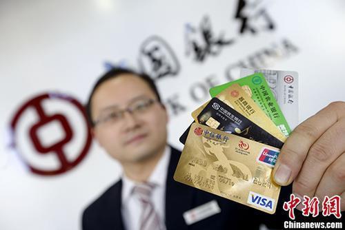 資料圖：山西太原的銀行工作人員展示各類信用卡。 <a target='_blank' href='http://www.chinanews.com/'>中新社</a>記者 張?jiān)?攝