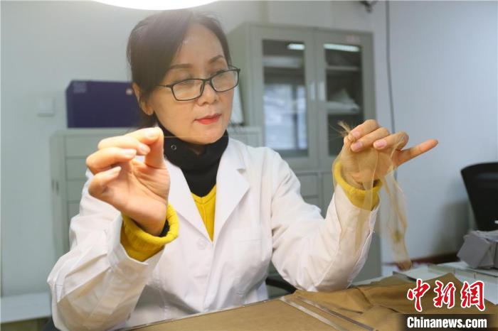 據(jù)趙喜梅介紹，修復(fù)文物紡織品所用的縐絲紗比頭發(fā)絲還細(xì)?！「哒?攝